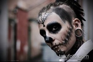Фото креативного макияжа, имитирующего татуировку черепа с элементами кружева. Выразительный взгляд и необычный образ.