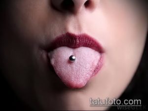 Фото пирсинга языка с серебряным шариком. Крупный план, видны губы и часть лица. Акцент на украшении и свежем проколе.