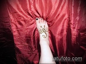 Фото тату хной на стопе: изображение скорпиона, выполненное коричневой хной на верхней части стопы.