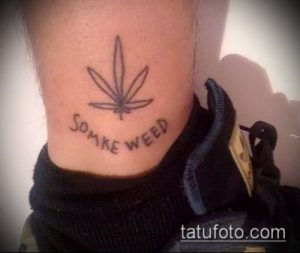 Фото простой татуировки листа каннабиса с надписью 'Smoke Weed' на лодыжке. Минималистичный рисунок татуировки в черно-белых тонах.