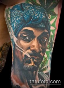 Фото тату: реалистичный портрет Snoop Dogg с сигаретой и листьями марихуаны на руке. Яркий и детализированный рисунок.