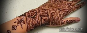 Фото тату хной на руке, с геометрическим узором, состоящим из квадратов и линий, выполненным в коричневых тонах.