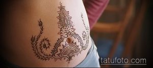 Фото тату мехенди на животе беременной женщины. Изображены сложные восточные узоры в коричневых тонах.