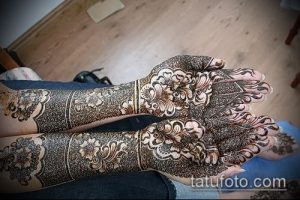 Фото тату мехенди: сложные узоры хной на руках и предплечьях, традиционный восточный стиль, коричневые и черные оттенки, высокая детализация.
