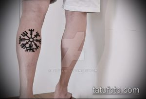 Фотография татуировки с изображением скандинавской руны на икре ноги.