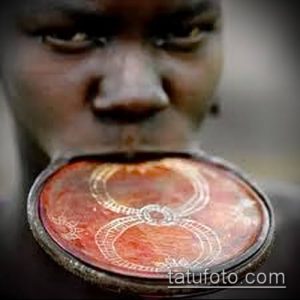 Фотография лица мужчины с пирсингом нижней губы с использованием больших круглых украшений. Этнический стиль.