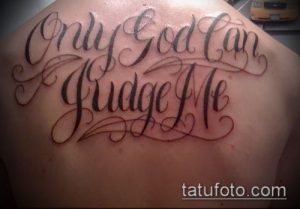 Фото тату надписи 'Only God Can Judge Me' на плече, выполненной изящным шрифтом с декоративными элементами.