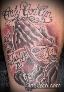 Фото тату с изображением молящихся рук и надписью 'Only God Can Judge Me'. Детализированный черно-серый рисунок татуировки.