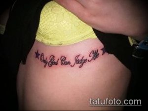Фотография татуировки с надписью 'Only God Can Judge Me' на боку, обрамленной двумя маленькими звездами.