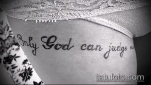 Фото татуировки с надписью 'Only God can judge me' черным цветом, выполненной каллиграфическим шрифтом на женском боку.