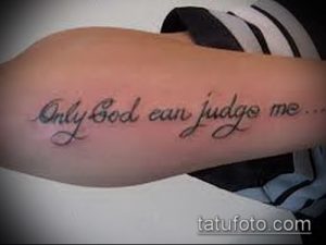 Фото тату надписи 'Only God Can Judge Me' черным цветом на предплечье. Классический шрифт и четкие линии.