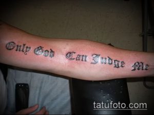 Чёрная татуировка на предплечье с надписью "Only God Can Judge Me", выполненная традиционным шрифтом.