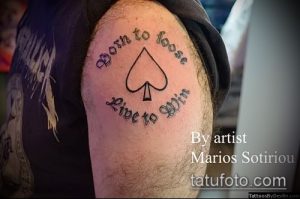 Фото тату с надписью 'Born to Loose, Live to Win' и изображением пиковой масти на плече.