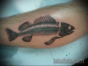Фото тату скелета рыбы на предплечье, выполненное в технике blackwork. Четкие линии, детальная проработка костей, минималистичный дизайн.