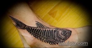Фото тату: изящный рисунок скелета рыбы в технике blackwork на запястье, с детально проработанной головой и плавниками.