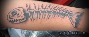 Фото тату: стильный рисунок скелета рыбы, выполненный в технике blackwork на руке. Идеальный эскиз тату для любителей графических и минималистичных дизайнов.