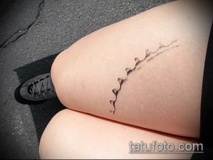 Фото тату на бедре: тонкая, минималистичная татуировка, имитирующая трещину на коже. Черно-серый рисунок татуировки.