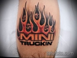 Фото тату на предплечье: огненные языки с черепами внутри и надпись 'MINI TRUCKIN''. Яркие цвета и четкие линии.