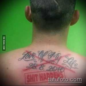 Фото тату на спине: надпись 'Love of My Life' перечеркнута и дополнена надписью 'Shit Happens'. Ироничный рисунок татуировки.