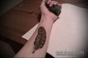 Фото тату: простое, но изящное изображение пера, выполненное хной на женском запястье. Идеально для тех, кто ищет небольшие и стильные идеи для тату.