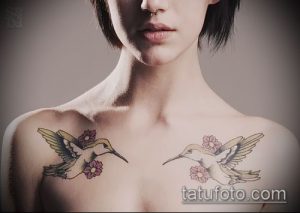 Фотография двух маленьких татуировок колибри на груди девушки. Тату выполнены в ярких цветах, с детальной прорисовкой крыльев и цветов.
