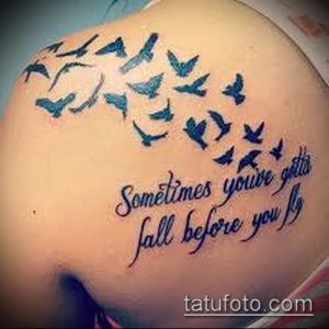 Фото тату: стая птиц, летящих над надписью "Sometimes you've gotta fall before you fly", выполненная на плече.