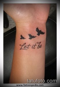 Фото тату на запястье с изображением трех птиц и надписи 'Let it be'. Минималистичный рисунок татуировки с позитивным посланием.