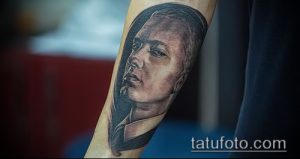 Фото черно-белой татуировки с изображением лица Эминема на руке. Минималистичный стиль, акцент на выразительности взгляда.