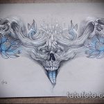 Черно-серый эскиз татуировки, изображающий череп, окруженный цветками лотоса и стилизованными рогами. Подходит для любителей готического стиля.