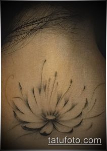 Фото тату: минималистичный эскиз лотоса в технике blackwork, расположенный на задней части шеи. Нежные линии и плавные переходы создают элегантный образ.