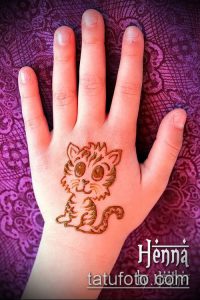 Фото тату милой кошки, нарисованной на ладони в стиле детского рисунка. Простой и очаровательный рисунок татуировки.
