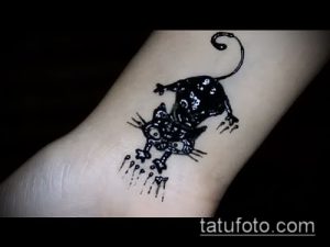 Фото тату черной кошки, словно выпрыгивающей из брызг краски. Оригинальный и креативный рисунок татуировки.