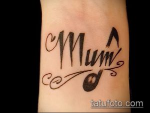 Фотография татуировки на запястье с надписью "Mum", стилизованной под музыкальную ноту. Нежный и трогательный рисунок татуировки.