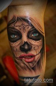 Фото татуировки на руке с изображением женского лица в стиле Катрина (Day of the Dead). Яркие цвета, детализированный рисунок.