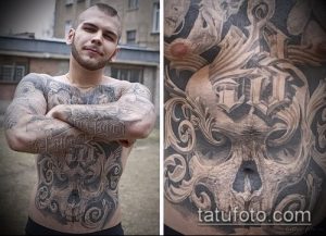 Фото тату на груди и руках с изображением черепа, окруженного сложным витиеватым узором. Детализированный рисунок татуировки в черно-серых тонах.