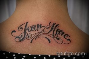 Фото тату на шее: стилизованная надпись 'Jean-Marc' с декоративными элементами, выполненная в черном цвете.