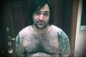 Фото тату на плече мужчины: изображение волка, выполненное в реалистичном стиле.