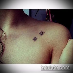 Фотография двух маленьких татуировок в виде звезд на плече девушки. Черно-белый рисунок.