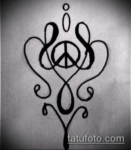 Фото тату с изображением символа мира, окруженного декоративными элементами. Черный рисунок, выполненный в изящном стиле.