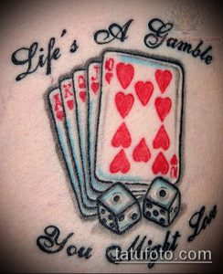 Фото тату: Композиция из игральных карт, костей и надписи "Life's A Gamble, You Might Love". Рисунок татуировки на плече.