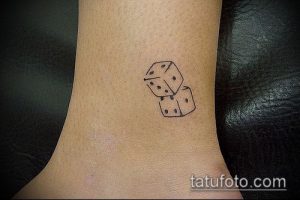 Фото тату: Маленькие черные кубики игральных костей на лодыжке. Простой и лаконичный рисунок татуировки.