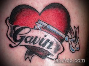 Фото тату: красное сердце с ключом и надписью 'Gavin' на руке. Классическая татуировка в стиле олдскул.