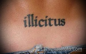 Фото тату надписи «illicitus» на груди. Черный цвет, простой шрифт, минималистичный стиль, татуировка для мужчин и женщин.