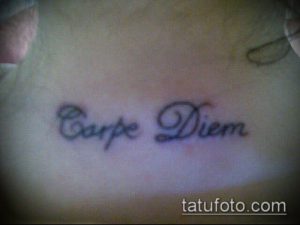 Фото тату надписи 'Carpe Diem' на груди. Черный цвет, каллиграфический шрифт, минималистичный стиль. Идеи для тату надписей.