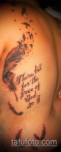 Фото тату с изображением пера и фразы "There, but for the grace of God, go I" на женском боку. Детализированный рисунок татуировки в черно-серых тонах.