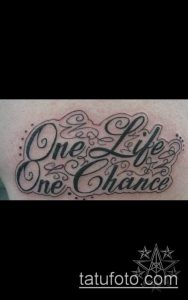 Фото тату надписи 'One Life, One Chance' выполненной в красивом каллиграфическом стиле. Черно-серая татуировка на коже.
