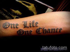 Фото тату на предплечье с надписью 'One Life One Chance' в готическом стиле. Темная и выразительная татуировка.
