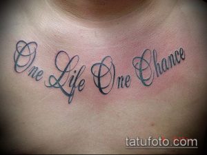 Фото тату на груди с надписью 'One Life One Chance' в изящном шрифте. Женственная и стильная татуировка.