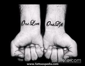 Фото парных татуировок надписей 'One Love' и 'One Life' на запястьях. Черно-серая татуировка, выполненная простым шрифтом.
