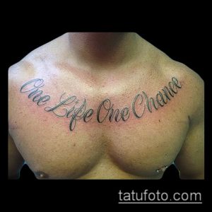 Фото тату надписи 'One Life One Chance' на груди мужчины. Черно-серая татуировка, выполненная каллиграфическим шрифтом.
